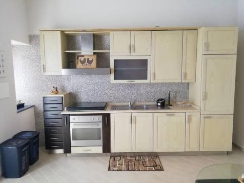 a kitchen with white cabinets and a sink at Casa Sambuco in Volla