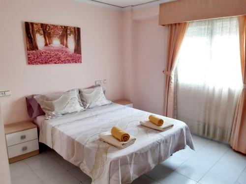 a bedroom with a bed with two towels on it at La Rose in Gandía