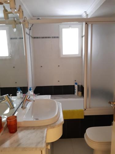 een badkamer met een wastafel, een toilet en een spiegel bij La Rose in Gandía