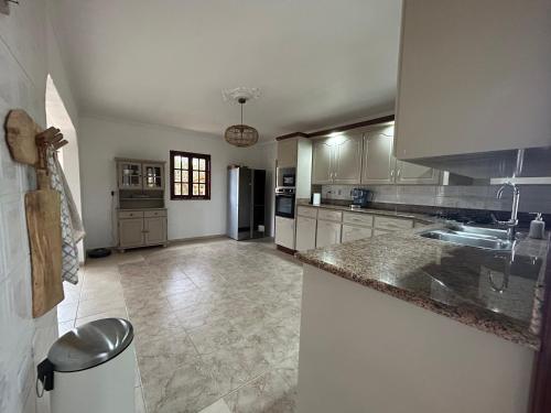 a kitchen with white cabinets and a counter top at Landhuis Belnem Bonaire in Kralendijk