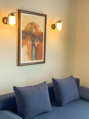 a couch with two pillows and a picture on the wall at Living Rooms Hotel in Skopje