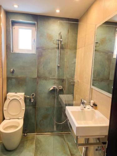 a bathroom with a toilet and a sink and a shower at Living Rooms Hotel in Skopje
