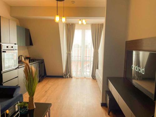 a living room with a large window and a television at Living Rooms Hotel in Skopje