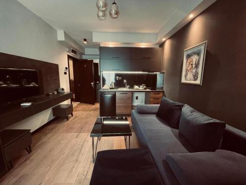 a living room with a couch and a kitchen at Living Rooms Hotel in Skopje