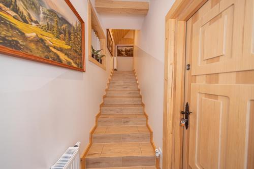 a hallway with a wooden door and a staircase at Apartamenty Zakopiańska Polana in Zakopane