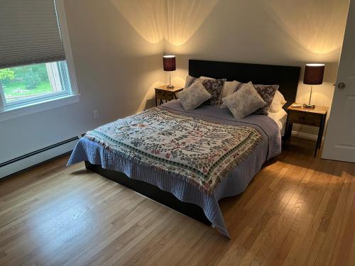 ein Schlafzimmer mit einem Bett mit zwei Nachttischen und einem Fenster in der Unterkunft Morning Sun in Middletown