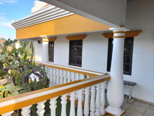 a white porch with a white railing and a house at Landhuis Belnem Bonaire in Kralendijk