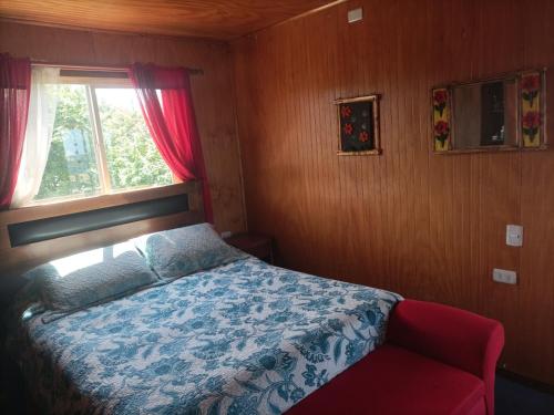 a small bedroom with a bed and a window at EL URCO CHILOE HOSTEL in Ancud