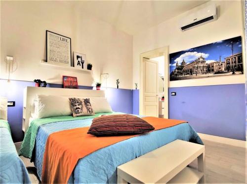 um quarto com uma cama grande e um cobertor laranja em Central Apartments®Borgo Street 1 min to Via Etnea em Catânia