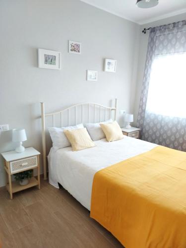 a bedroom with a large bed with a yellow blanket at Montaña & Mar in Miami Platja