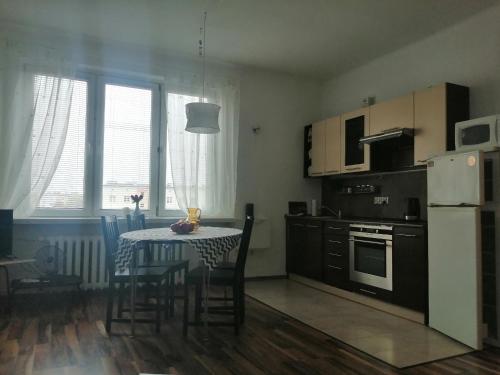 una cucina con tavolo, sedie e frigorifero di Parkowy Apartment a Bydgoszcz