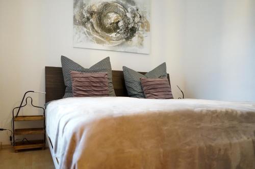 3-Raum City-Appartement Jena في جينا: غرفة نوم بسرير كبير عليها مخدات