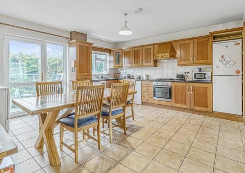 a kitchen with wooden cabinets and a table and chairs at En-Suite room in Carlow Town in Carlow