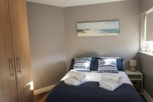 um quarto com uma cama com almofadas azuis e brancas em En-Suite room in Carlow Town em Carlow