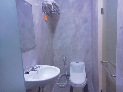 Baño pequeño con lavabo y aseo en Kelud Syariah Guesthouse, en Blitar