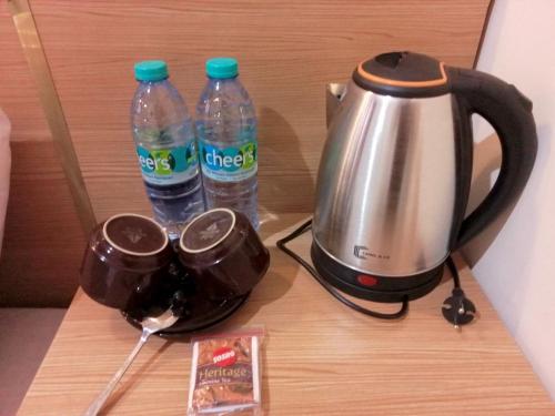 a tea kettle and two bottles of water on a table at Kelud Syariah Guesthouse in Blitar