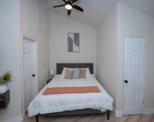 a white bedroom with a bed with a ceiling fan at Modern Studio Type Apt close to Botanical Gardens in Huntsville