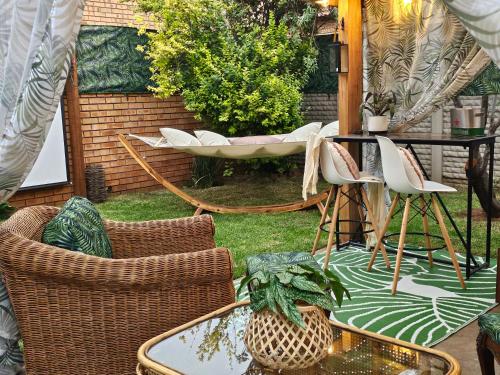 a patio with wicker chairs and a table and a table and chairs at Villa La'Vie in Witbank