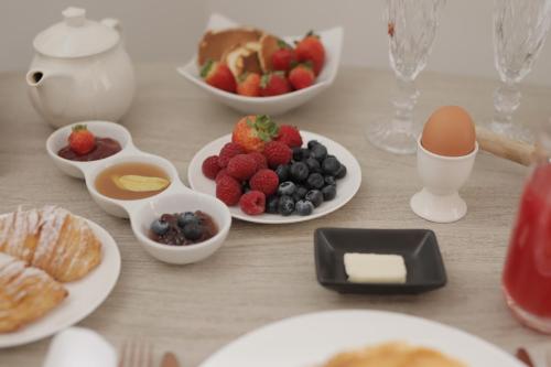 a table topped with plates of fruit and eggs at UNA HOTELS Tenuta Contessa Farm & SPA Cosenza in Montalto Uffugo