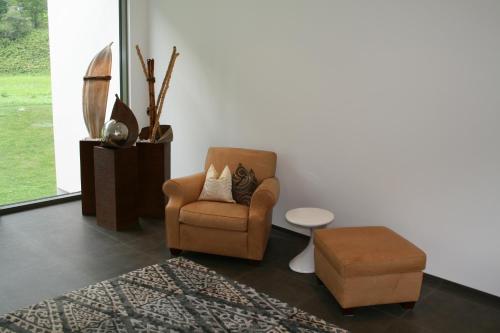 a living room with a chair and a stool at Laudinella - Apart in See