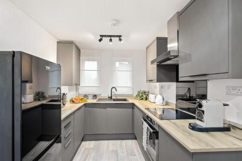 a kitchen with white cabinets and stainless steel appliances at ELEGANT suburban APARTMENT in Peterborough