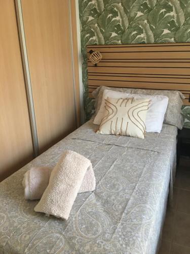 łóżko z dwiema poduszkami na górze w obiekcie Superbe appartement avec piscine à 800m de la mer w mieście Bahia de Casares