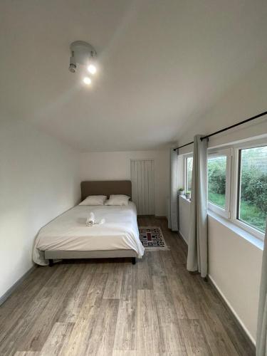 une chambre avec un lit et une grande fenêtre dans l'établissement Au logis du circuit des 24h00, au Mans