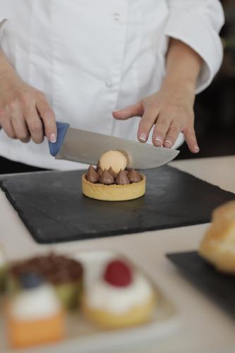 a chef is cutting a piece of food with a knife at UNA HOTELS Tenuta Contessa Farm & SPA Cosenza in Montalto Uffugo