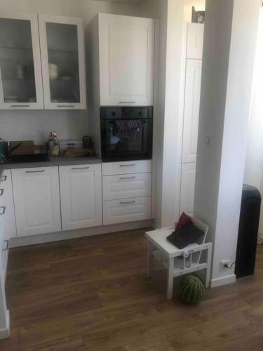 une cuisine avec des armoires blanches et une table à l'intérieur dans l'établissement La Grande Motte, centre-ville, plage à 150 mètre, à La Grande Motte