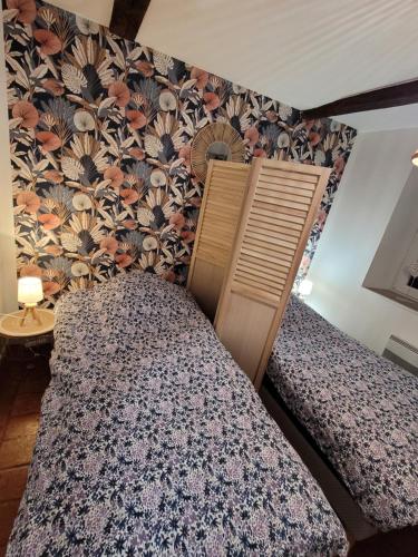 1 dormitorio con 2 camas y papel pintado con flores en Bienvenue du côté de chez nous en Wignehies