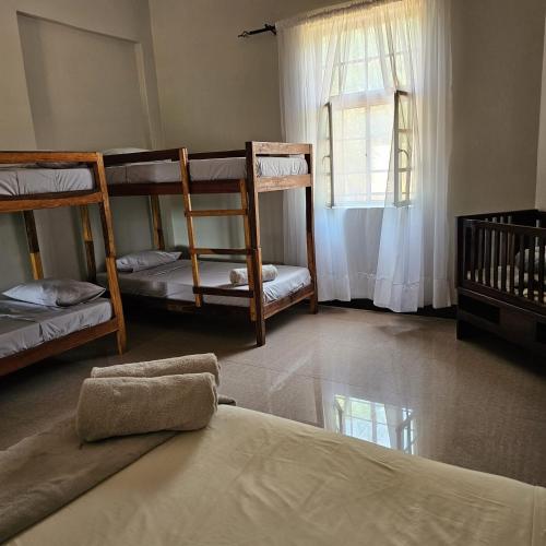 a room with three bunk beds and a window at Mukamba Holiday Accommodation in Livingstone