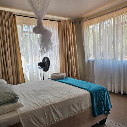 a bedroom with a bed and a large window at Mukamba Holiday House in Livingstone