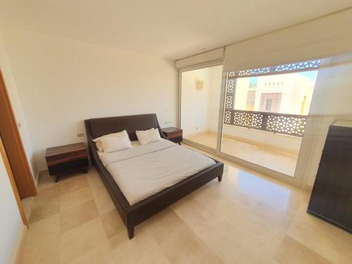 a bedroom with a bed and a large window at Nayah Stays, Beautiful 3-bedroom vacation home with lovely pool in Hurghada