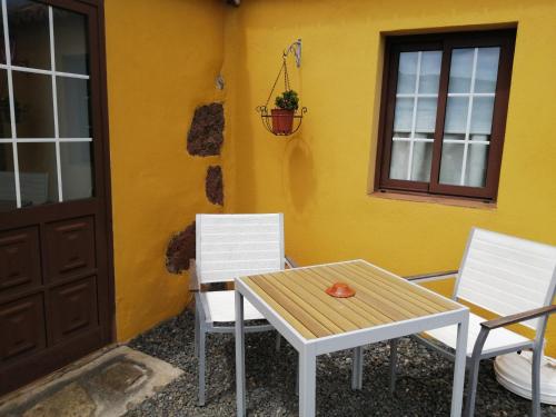 a table and two chairs in front of a house at Casa La Rehoya in Puntallana