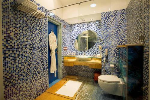 een badkamer met een toilet, een spiegel en een wastafel bij I Love Bell Bottoms Vagator Goa in Anjuna