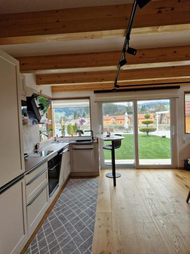 a kitchen with wooden ceilings and a large window at FERIENHAUS A&C DELUXE AM SEE in Spielberg