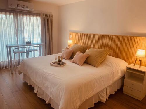 a bedroom with a large white bed with a table at Tigre Urban Suites in Tigre