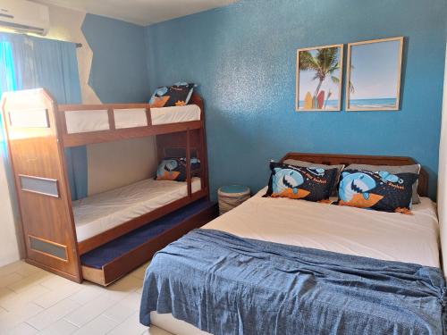 1 Schlafzimmer mit 2 Etagenbetten und einer blauen Wand in der Unterkunft Praia Flat in São José da Coroa Grande