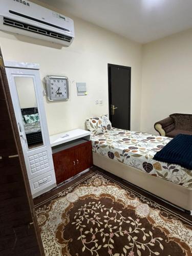 um quarto com uma cama, um lavatório e um espelho em لولي قست هاوس em Al Ain