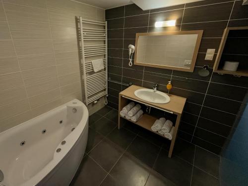 y baño con bañera, lavamanos y bañera. en Apartmajska hiša Breza en Ribnica na Pohorju