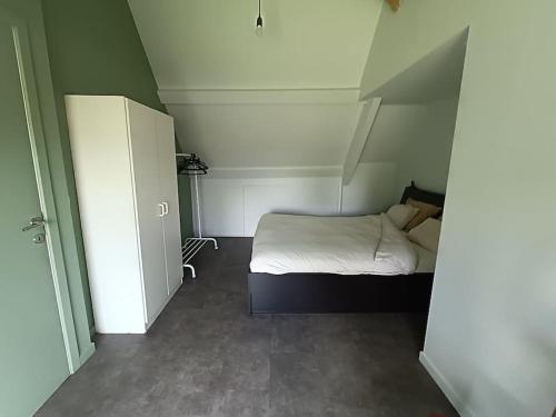 a small bedroom with a bed and a closet at Huis Belijn in Lokeren