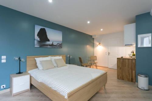 a bedroom with a large bed and a blue wall at Rose, Appartement Confortable proche Metro in Montrouge