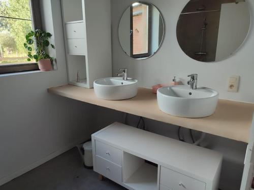 a bathroom with two sinks and a mirror at Huis Belijn in Lokeren