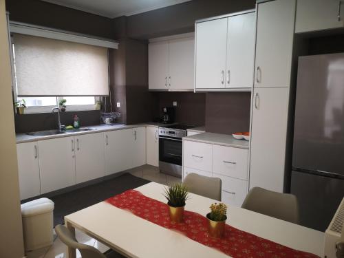 uma cozinha com armários brancos e uma mesa com um tapete vermelho em Athenian Luxury apartment, near metro station Chalandri, Nu 1 em Atenas
