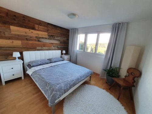 a bedroom with a bed and a wooden wall at Apartment in Swiss Chalet Träumli in Meierskappel