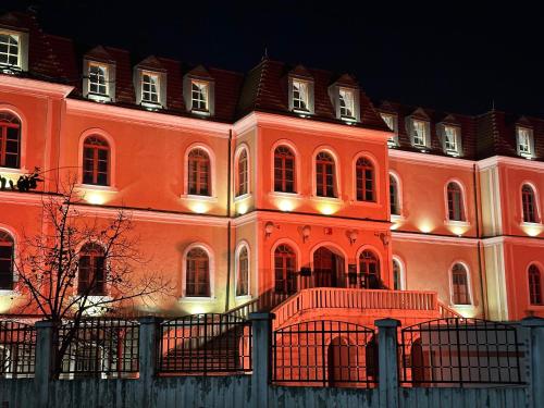 um grande edifício laranja com luzes acesas à noite em Hostel Prishtina Backpackers em Pristina