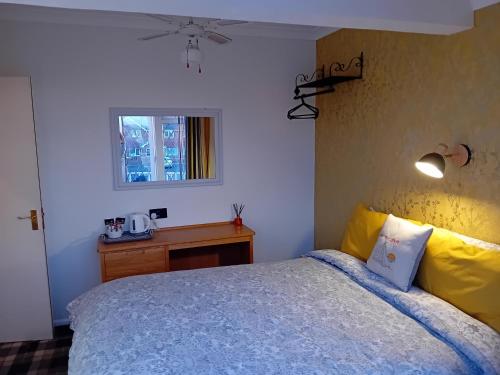 a bedroom with a bed and a table and a window at Sea Air B&B in Chapel Saint Leonards