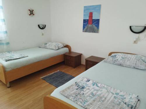 a room with two beds and a picture of a rocket at Apartman Barbara in Cres