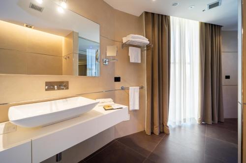 bagno con lavandino bianco e specchio di Tenuta Contessa - Relais & Spa a Montalto Uffugo