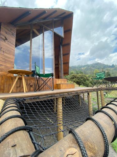 une maison en bambou avec un filet sur la terrasse dans l'établissement Cúspide, à Choachí
